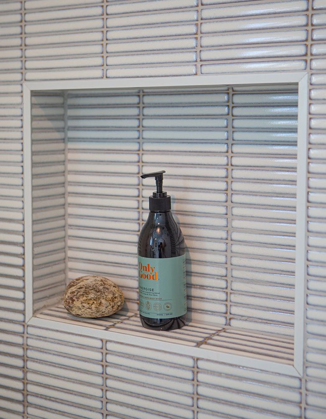 Recessed tiled shower niche.