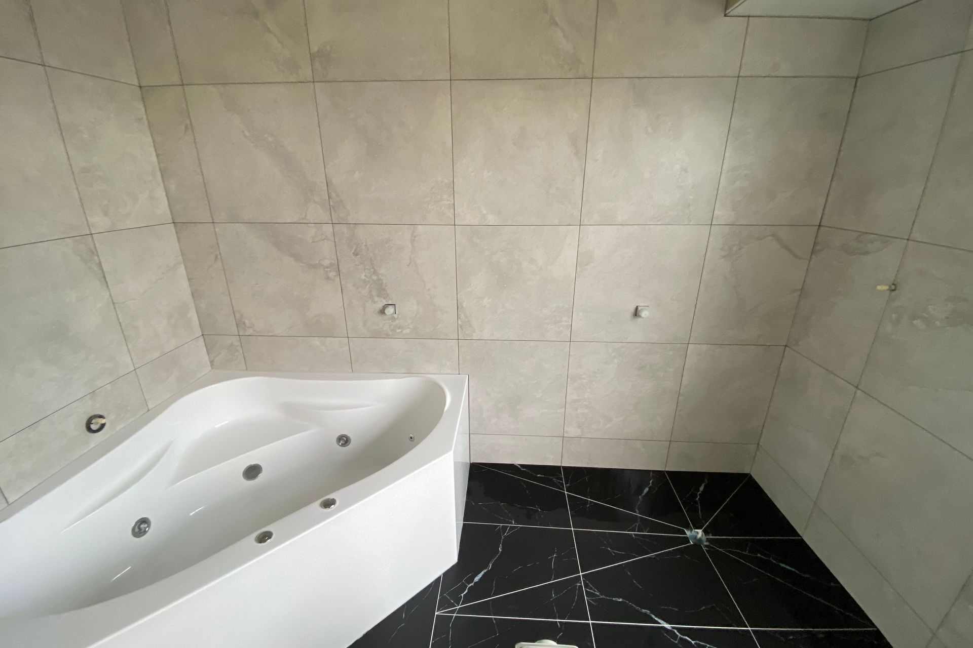 Tiled bathroom floor &amp; walls.
