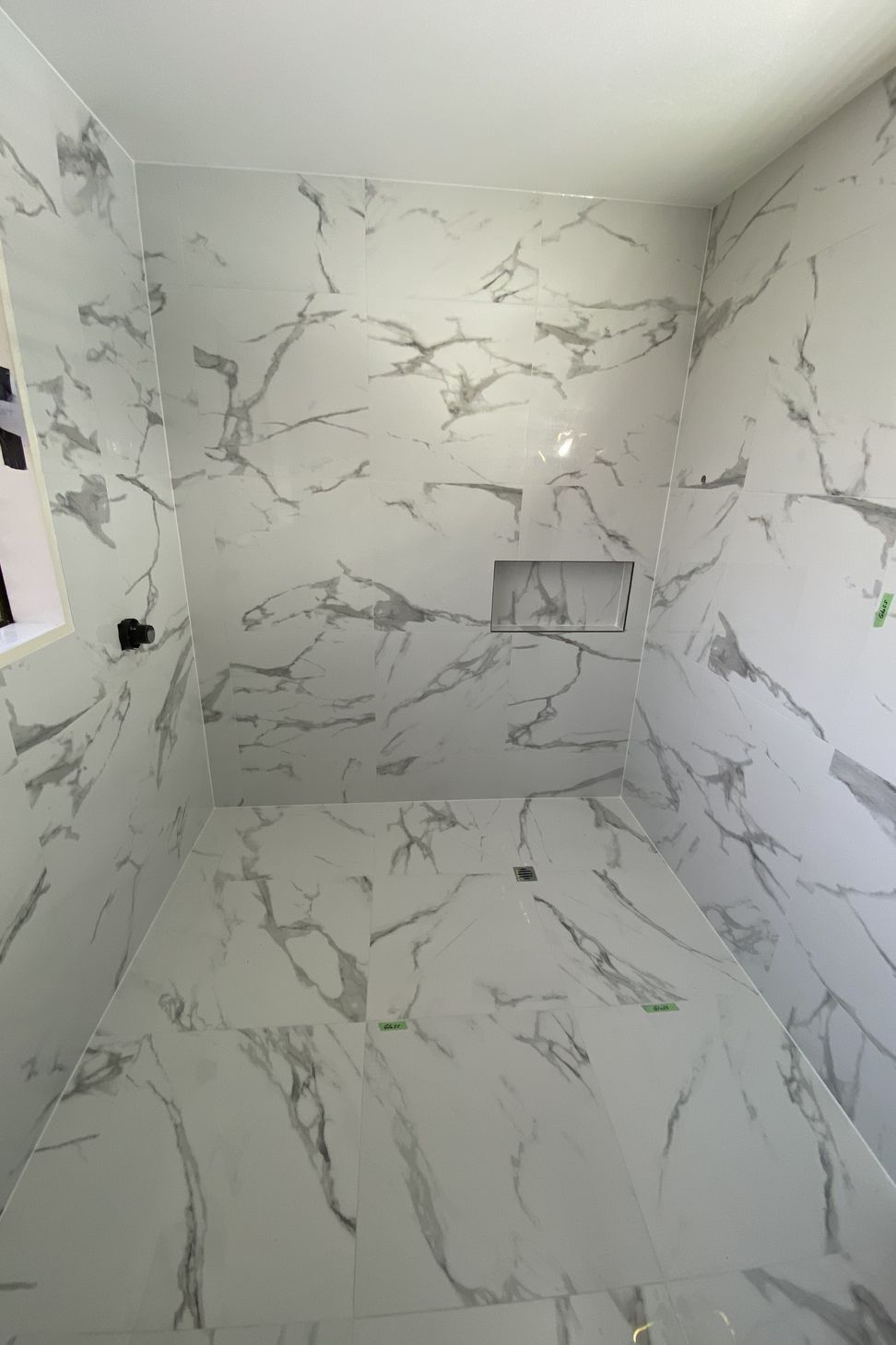 Tiled bathroom floor &amp; walls.