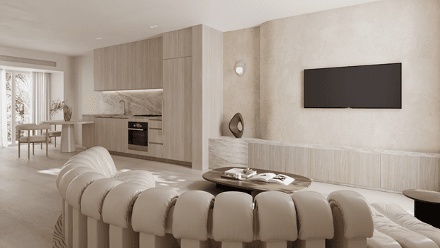 A refined open-plan living and dining area with a contemporary neutral palette. A sculptural curved cream sofa faces a textured feature wall with a mounted black artwork and integrated linear timber-toned media cabinetry. Behind it, a compact kitchen features full-height light timber cabinetry, a pale stone-look splashback and built-in oven, while a small dining table sits beside large glazed doors.