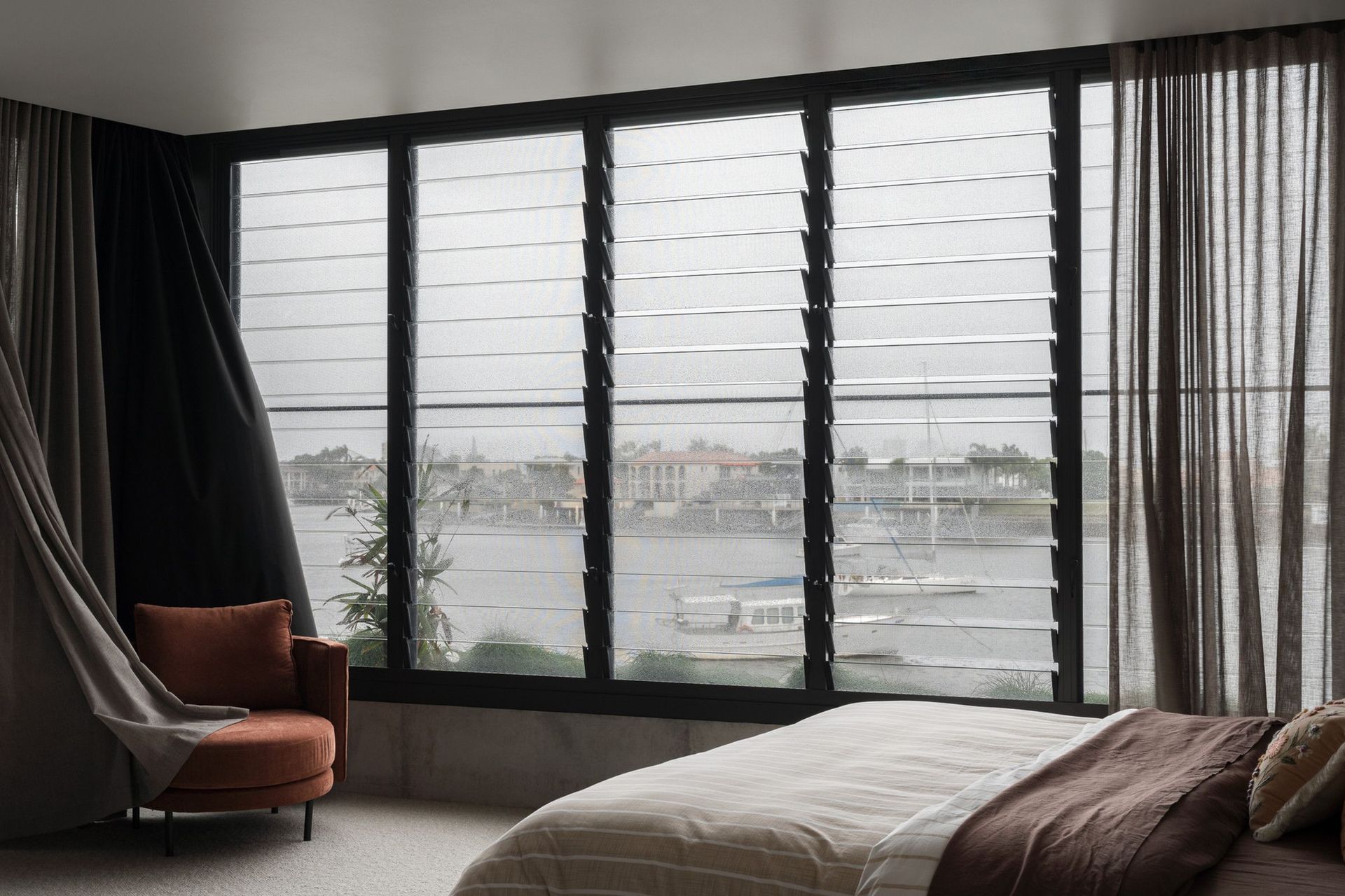 Carwoola House - Bedroom. Bedroom with louvred windows framing water views.