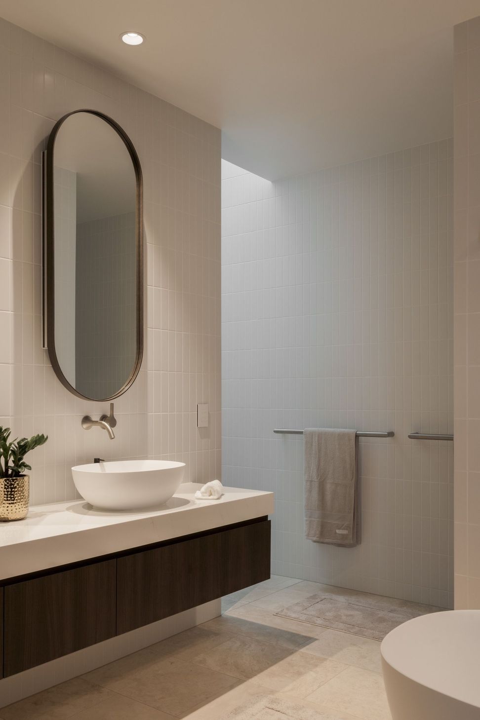 Carwoola House - Bathroom. Oval mirror and vessel basin on a timber vanity.