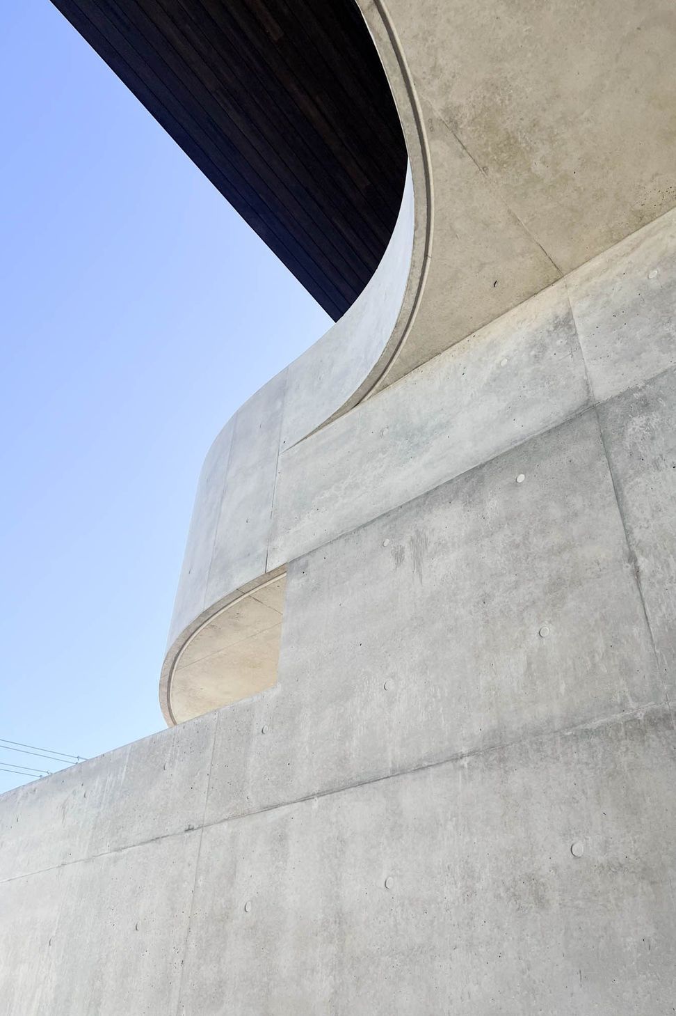Carwoola House - Exterior. Off-form concrete curve rising into the sky.