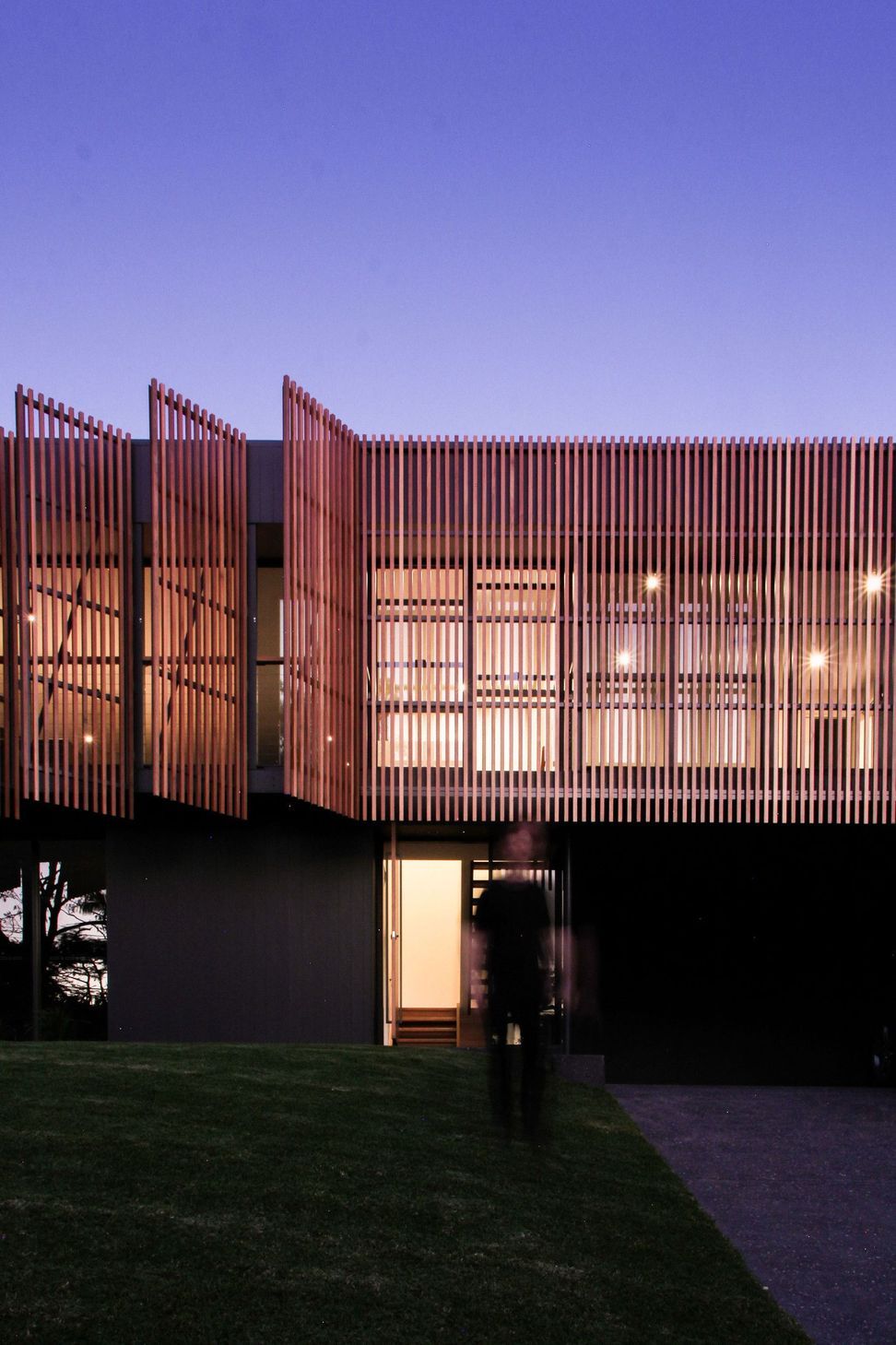 Glennon Residence - Exterior. Timber screens glowing at dusk.