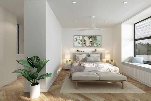 Bright contemporary bedroom with a large upholstered bed, layered neutral bedding, bedside tables and lamps, a slim upholstered bench, and framed botanical artwork. The room features white walls, recessed lighting, a ceiling fan, warm herringbone timber flooring, a built-in window seat beneath expansive glazing, and a large potted tropical plant.