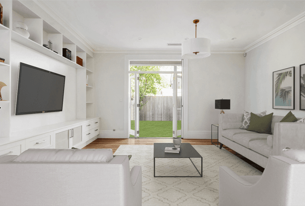 Bright, refined living room with white built-in shelving and media cabinetry, a wall-mounted television, pale upholstered sofas and armchairs, a black metal coffee table, patterned area rug, framed botanical artwork, and a central glazed door opening to a small garden. The room has traditional detailing such as decorative cornices and timber flooring, combined with contemporary furnishings.