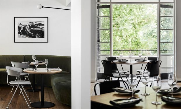 A split view of two stylish dining settings. On the left, a compact round dining table with white chairs sits beside a dark olive-green banquette, with timber flooring, monochrome artwork, and a minimalist wall light. On the right, a larger dining area features black dining chairs, set tables, and expansive black-framed multi-pane glazing overlooking leafy greenery. The overall design is refined, monochromatic, and contemporary.
