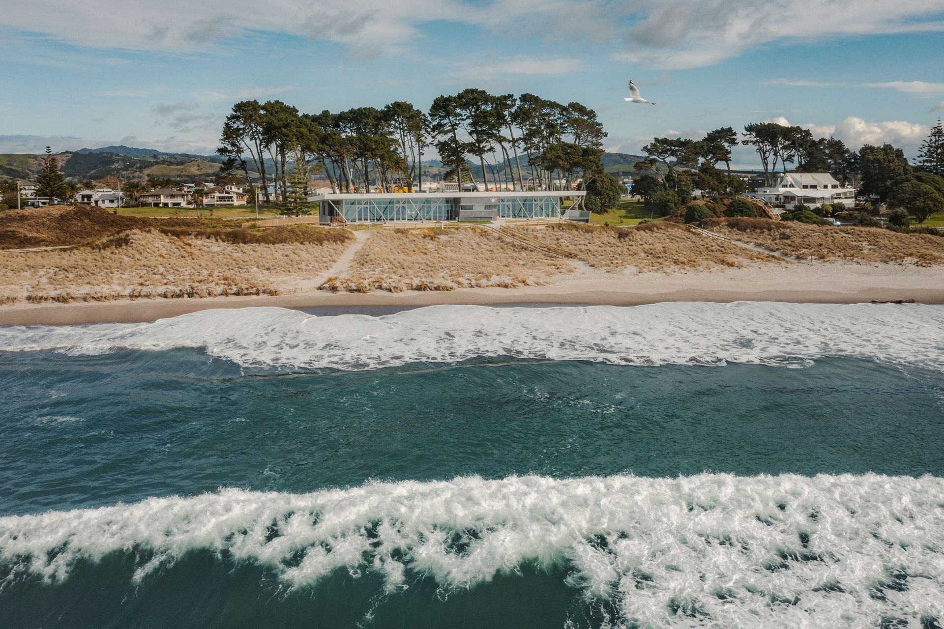 The finished product sits on the dunes of Papamoa Beach, its exterior complementing the surrounding shrubbery and other natural features of the coast.
