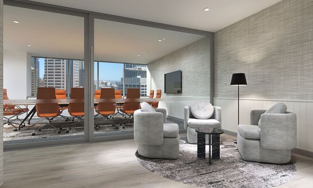 Contemporary office lounge overlooking a city skyline, with two sculptural light-grey armchairs, a small black side table, floor lamp, wall-mounted television, and a round rug. A glazed meeting room with orange office chairs and a conference table is visible behind the lounge. The space features light timber flooring, pale textured wall finishes, recessed ceiling lighting, and full-height internal glazing.