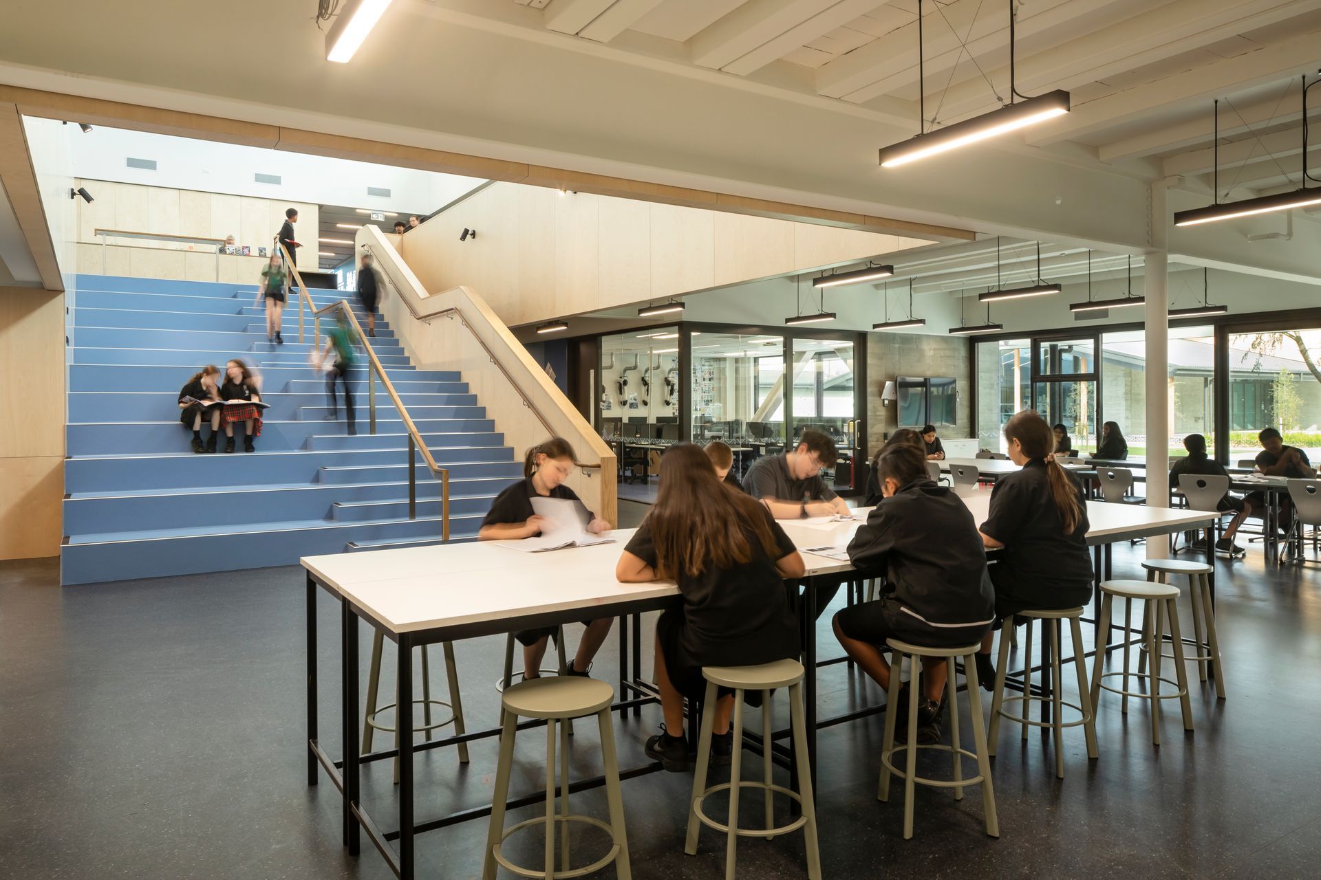 Students work in open-plan break-out spaces in the 'maker' hub.