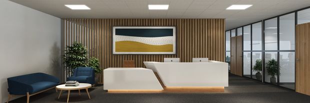 A contemporary commercial reception area with a white reception desk positioned against a warm vertical timber-slat feature wall. The space includes a dark blue sofa and lounge chair, a small round timber coffee table, indoor plants, framed artwork, carpet flooring, and black-framed glazed office partitions. Recessed rectangular ceiling lights provide even illumination.