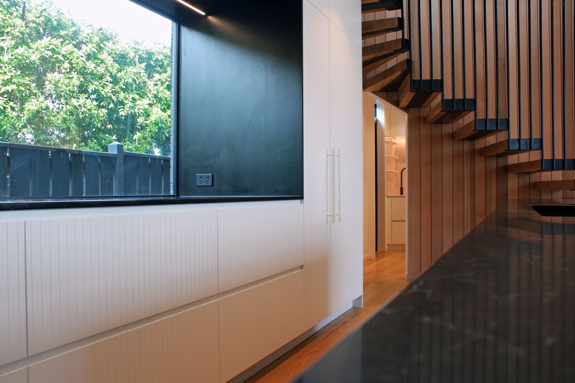 White V groove, black island and a scullery with a touch of pink