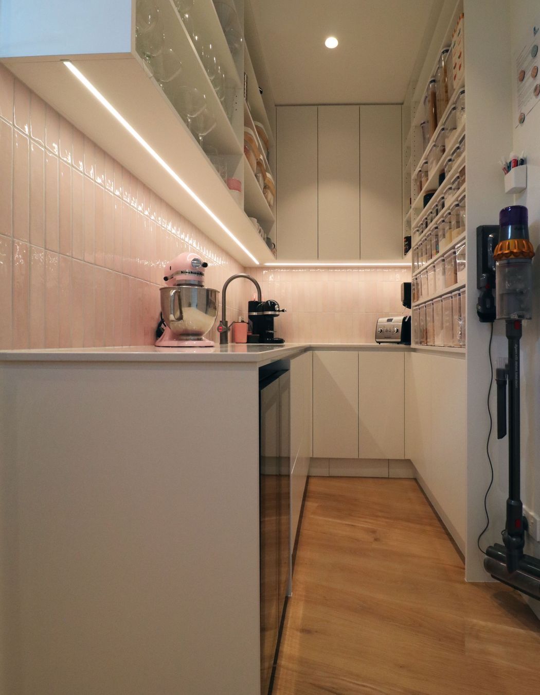 White V groove, black island and a scullery with a touch of pink