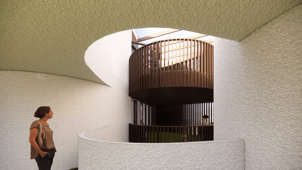 A sculptural architectural interior courtyard or circulation space framed by curved, textured off-white plaster walls and ceiling. A rounded opening reveals a multi-level timber-slatted balcony or stair enclosure with warm brown vertical battens, while a person provides scale. Natural light enters from above, creating a calm, organic and contemporary atmosphere.