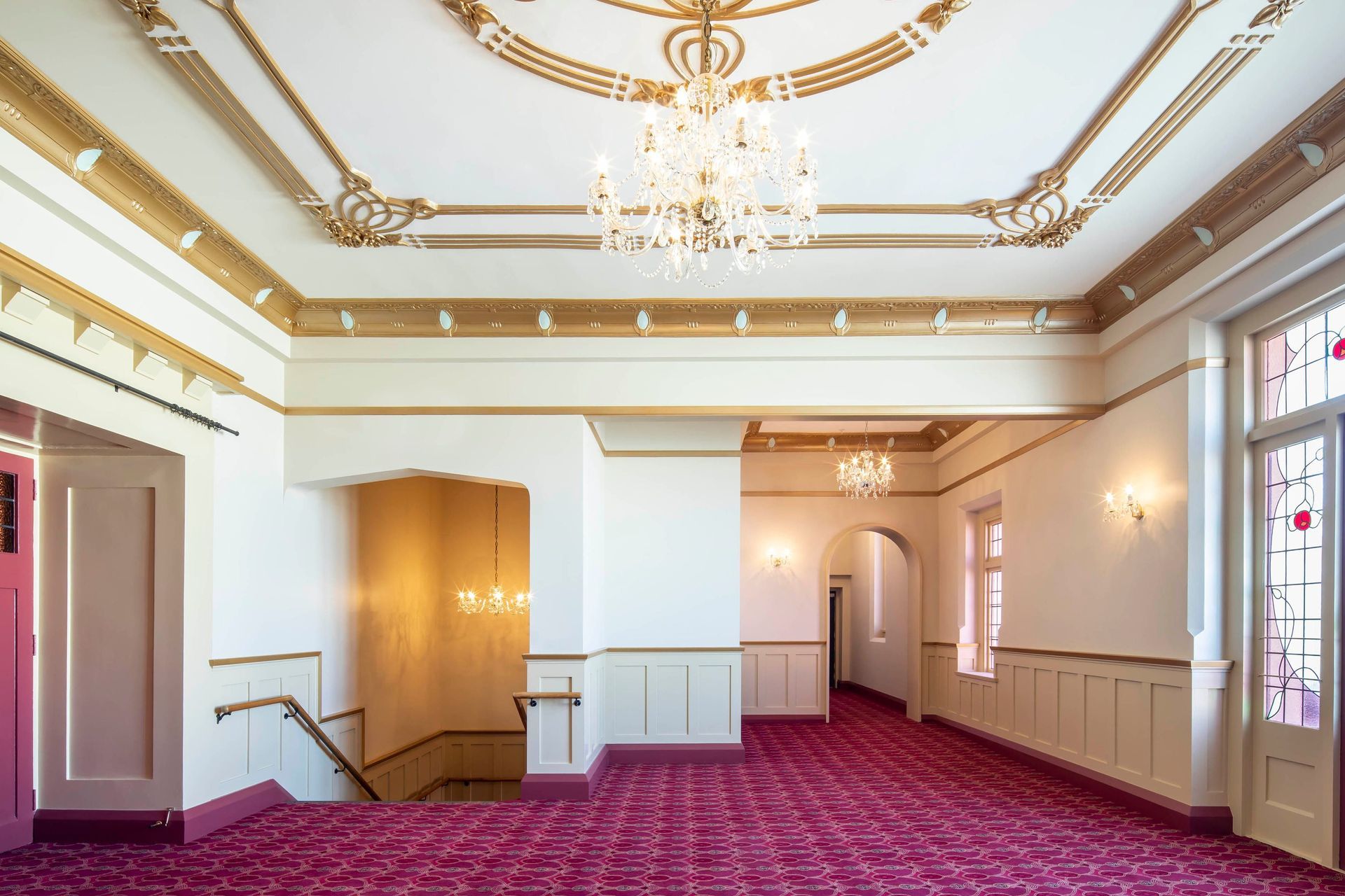 Formerly dark and seemingly confined spaces such as the upper and lower foyers have been transformed by a palette of neutrals, contrasting with specially designed carpets with rich red tones and lavishly finished, gold-painted plaster cornices.