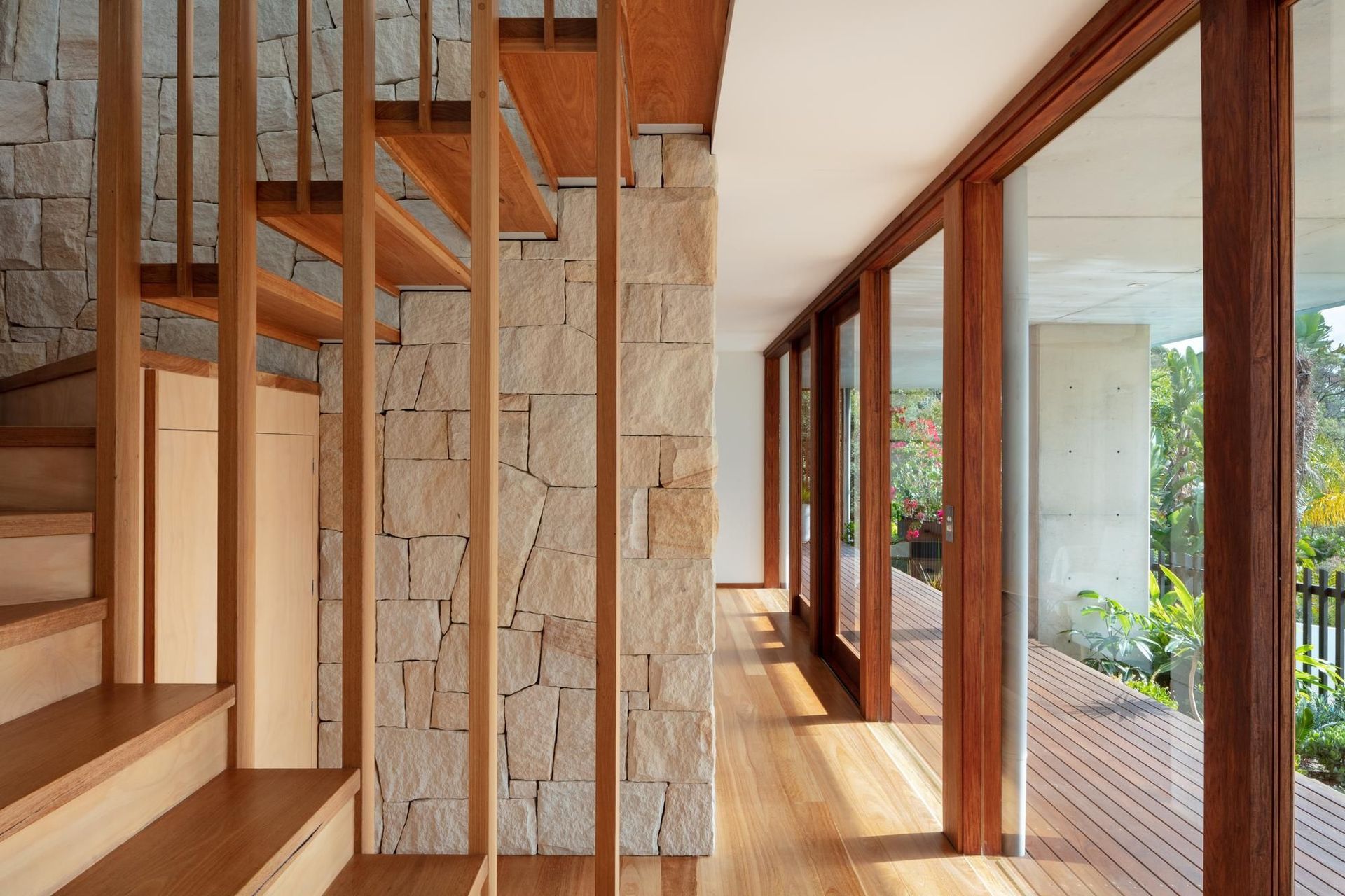 13-Matt-Day-Architect-Matt-Day-Bayview-House-Stair-Timber-Battens-Sandstone-Wall-Timber-Floor-Timber-Sliding-Doors.jpg