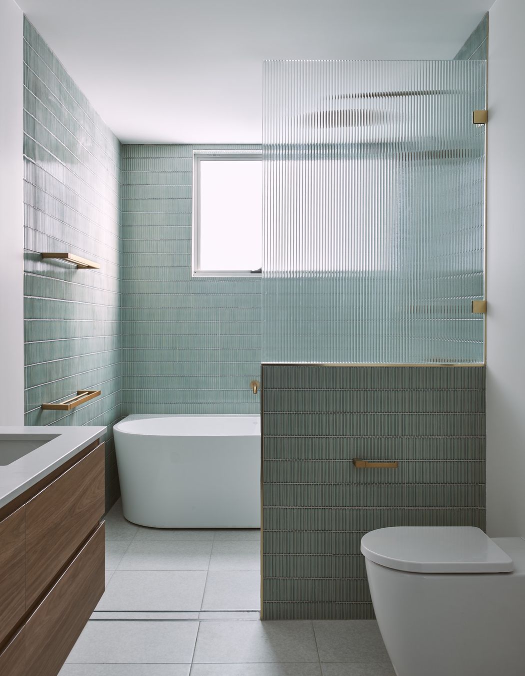 Green finger tiles and fluted glass cut the ensuite to a different class. Brass fixtures and ornate lights embellish the private bathroom.