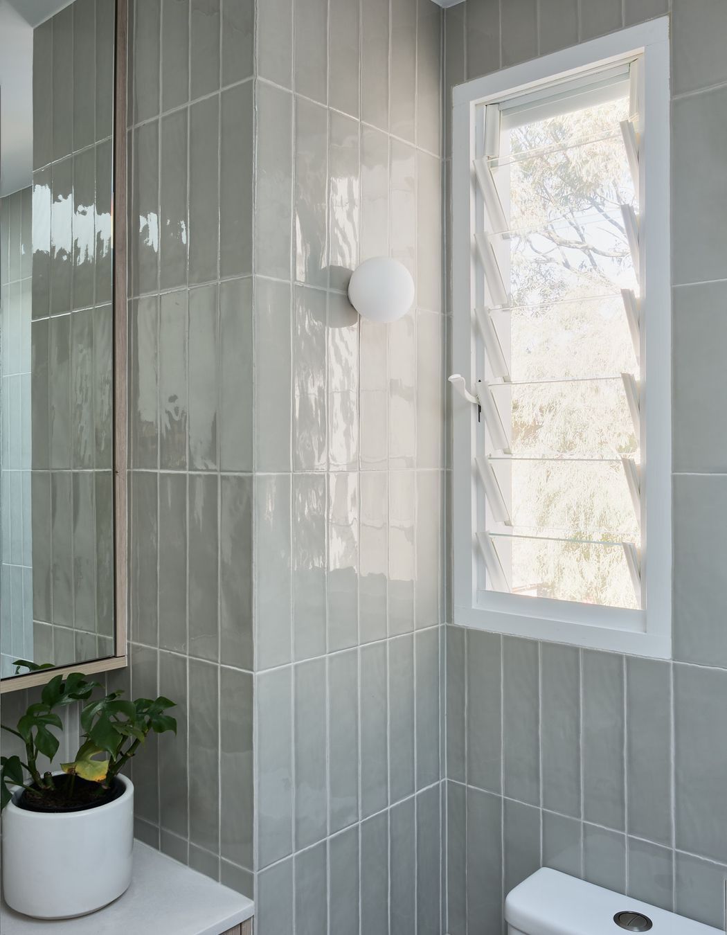 The tone enhances the natural feel connecting the interior with the tree canopy views through the windows.