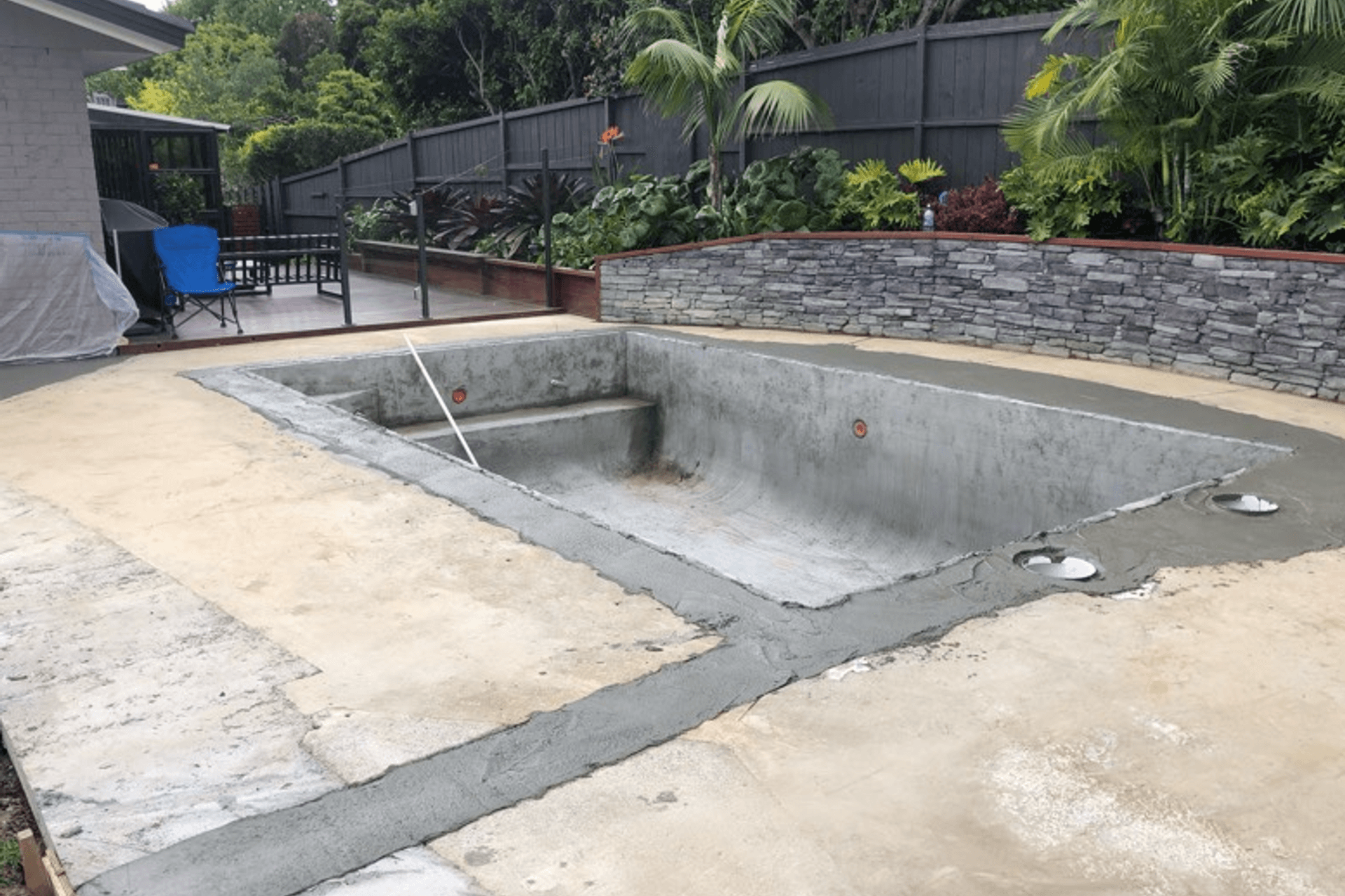A newly sprayed concrete pool - ground plumbing newly installed and the old pool shape is visible that has had freshly filled with poured concrete.  The pool area can now be prepped for laying of new pavers &amp; coping and the cosmetic works can begin on the pool interior, including new pool plant installed.