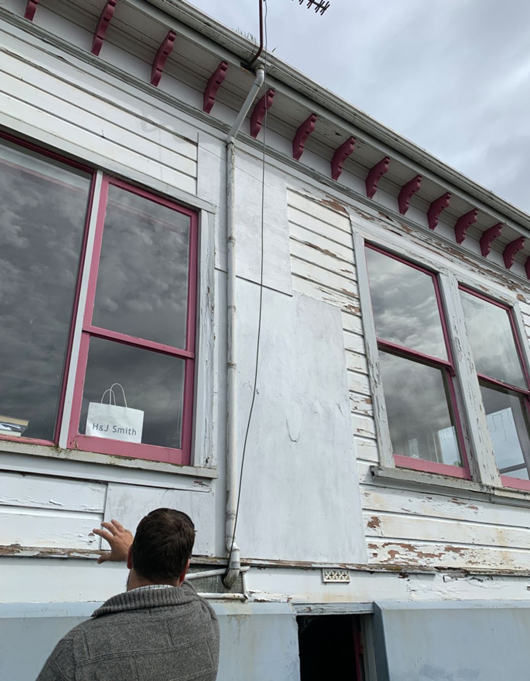 B4-9-Fifield-St-Roslyn-Dunedin-Jeff-inspecting-damaged-windows-and-weatherboards-on-the-east-side-before-renovation-JDBuilders.jpg