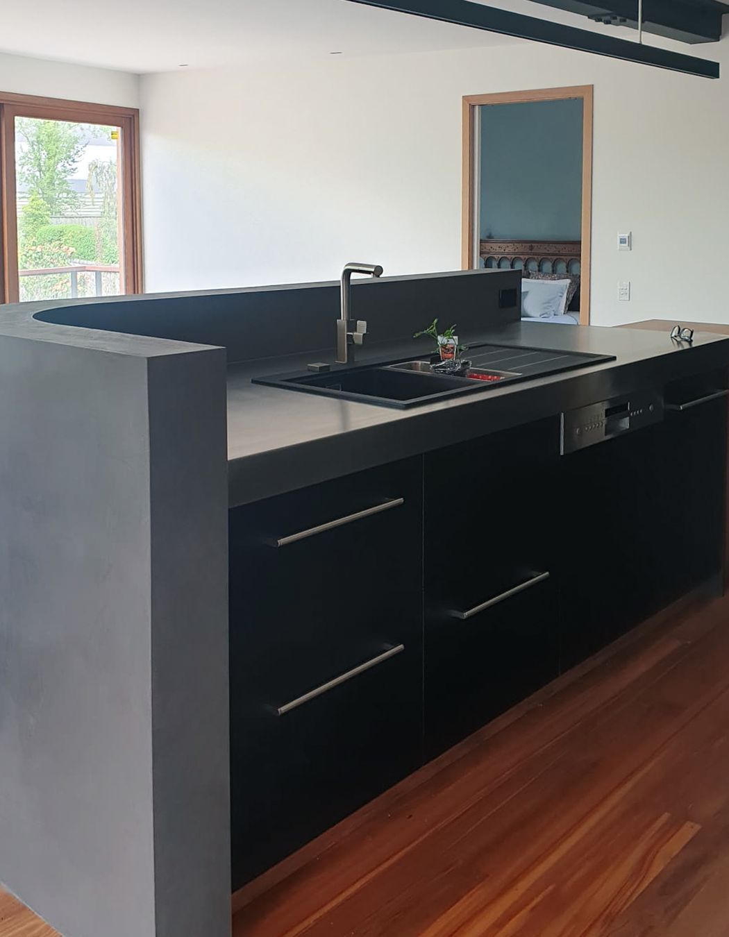 Dark polished plaster applied to the inside of this curved wall for the splashback.