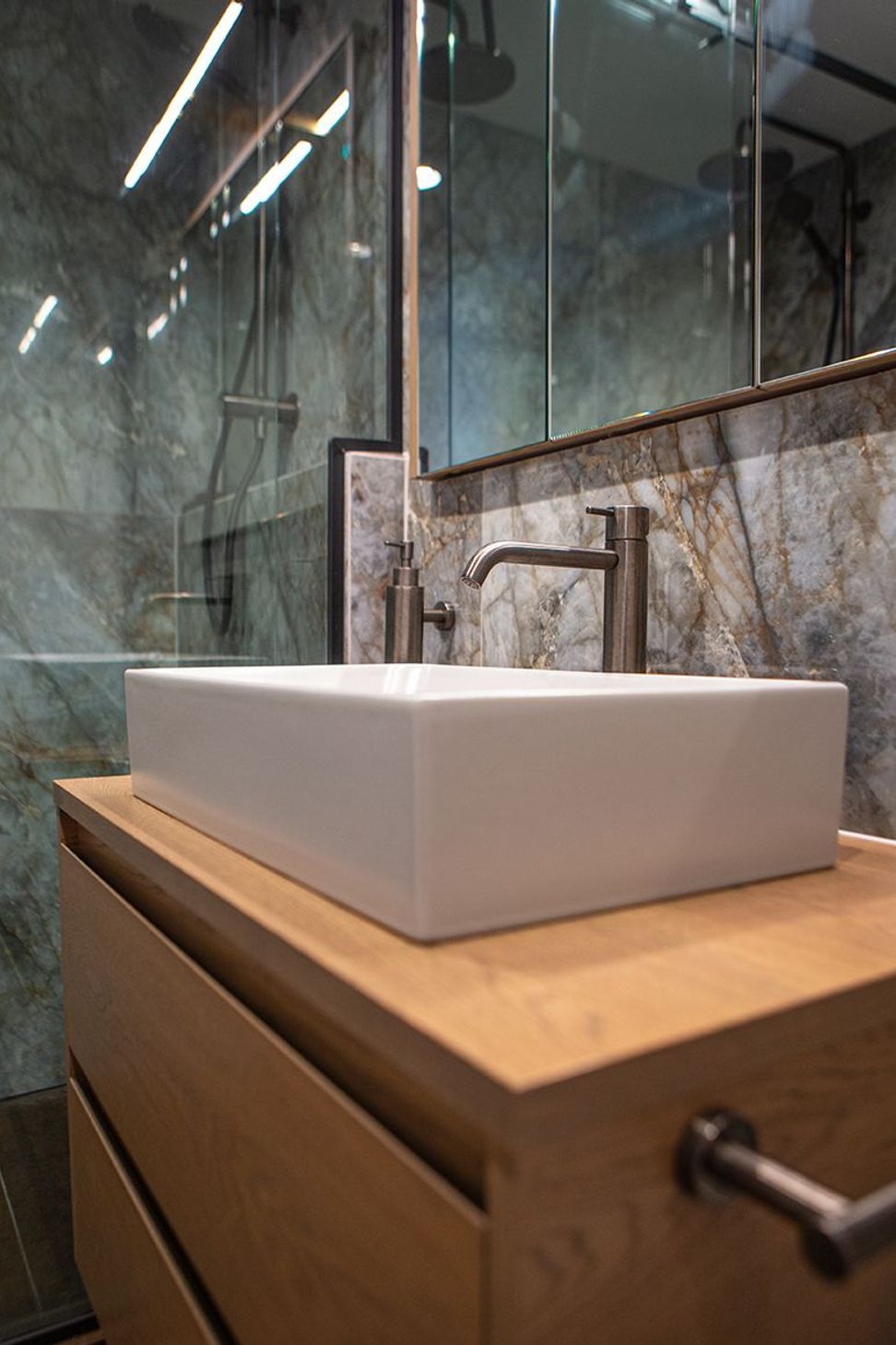 A rectangular vessel basin sits atop the oak two-drawer vanity.