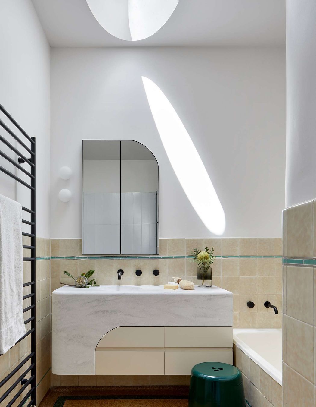 Art Deco bathroom, featuring original 1930’s cream textured tiles with green accent tile line and bath (resurfaced). Vantity designed by Hindley &amp; Co with curved Corian top and siding, hand crafted by JFJ Joinery. Matching curved mirrored medicine cabinet by Hindley &amp; Co. The project is a 1930s art deco spanish mission style house in Melbourne. See more from our Arch Deco Project.