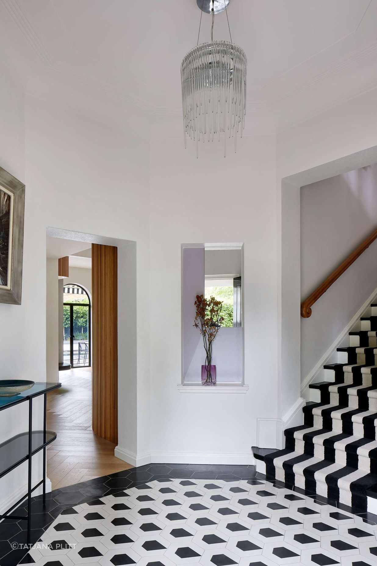 Large black and white art deco entryway with geometric concrete matt tiling from Perini, matched with black and white stairway carpet runner. The project is a 1930s art deco spanish mission style house in Melbourne. See more from our Arch Deco Project.