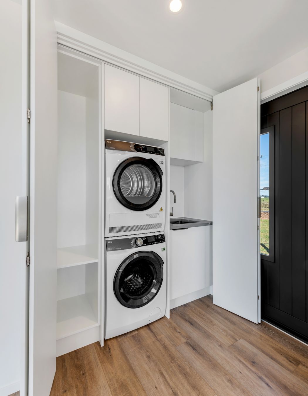 “One of my favourite little details.”  - We tucked a full laundry into this cabinet—stacked washer-dryer, overhead storage, all out of sight but easy to get to.