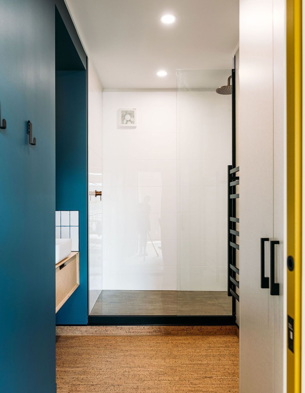 A step up into the shower was retained in the penthouse bathroom to work around existing plumbing constraints.