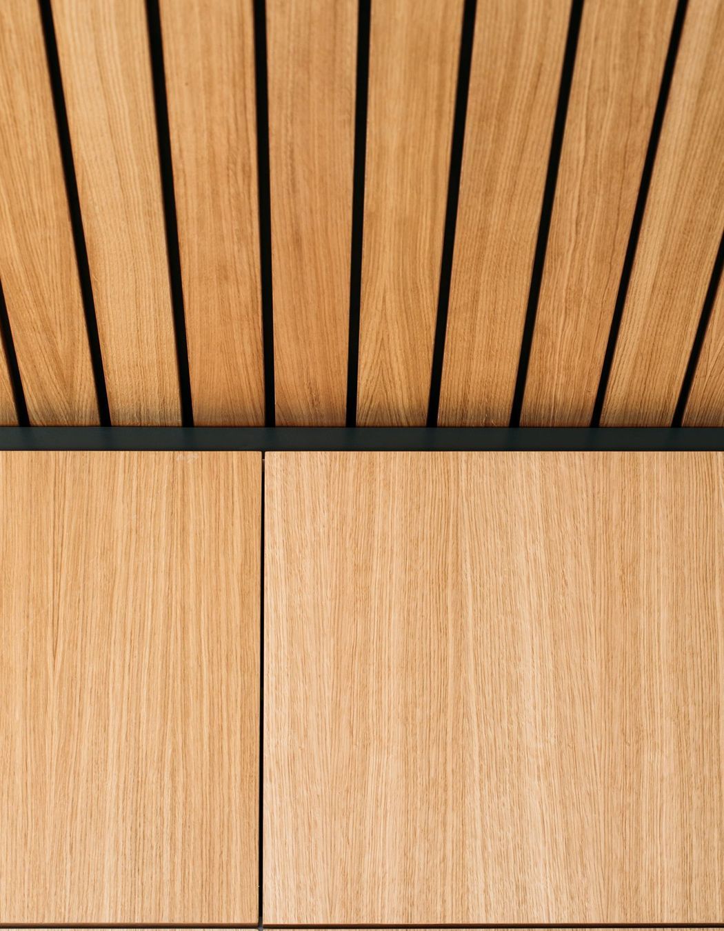 Matt black negative detail is added above the cabinetry to meet the ceiling feature.