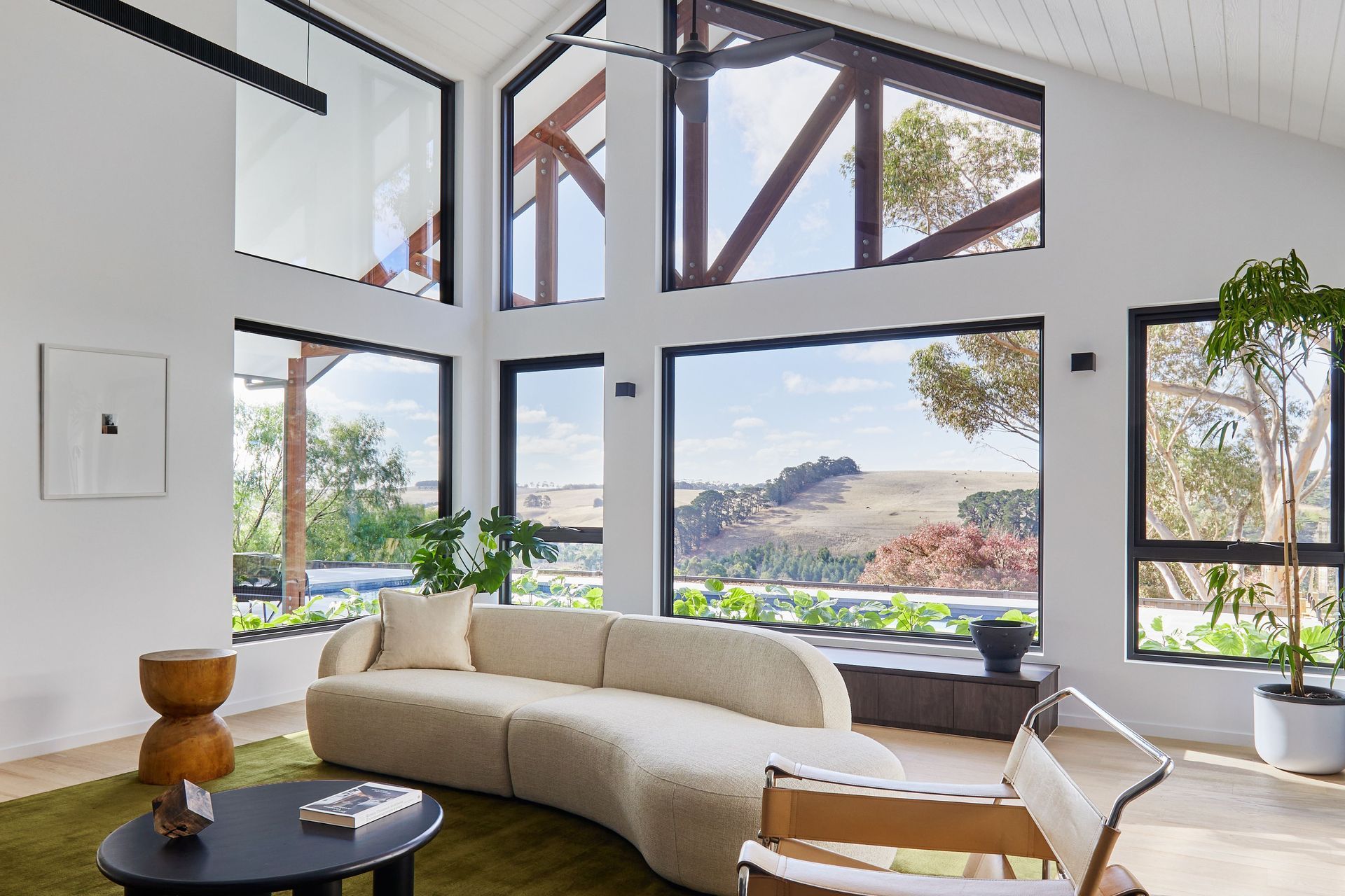 Modern living room interior with large windows overlooking the countryside in Waurn Ponds, VIC. Designed by RUBI Architects, built by Fox Building Group.