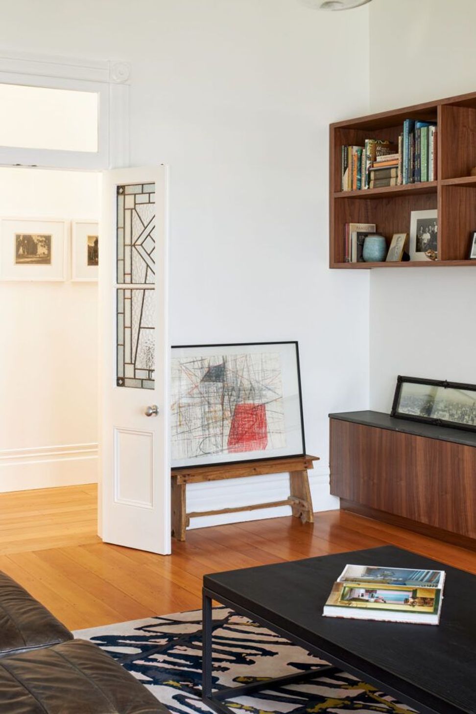 Looking back towards the heritage hallway, original leadlight doors create a graceful transition between the restored villa and the contemporary living spaces.