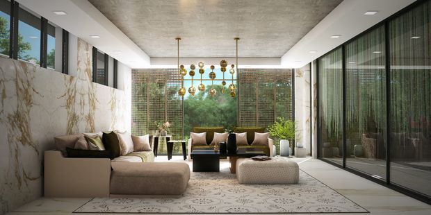 A luxurious contemporary living room with floor-to-ceiling glazing on both sides, opening visually toward a lush garden. The room features a large sectional sofa, ottomans, patterned area rug, sculptural gold pendant light, marble-look wall cladding, dark-framed glass doors, and a textured concrete-look ceiling. The space is bright, refined, and strongly connected to the outdoors.