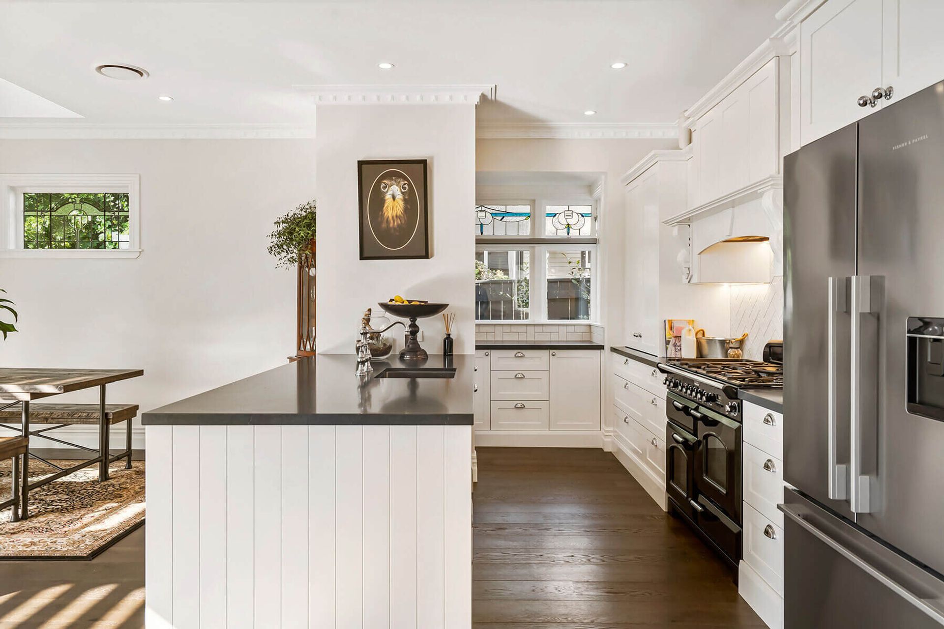The new kitchen features custom built cabinetry and high end appliances. It has a large scullery with a sink and plenty of storage tucked around the back, with windows looking out to the garden to bring in plenty of light.