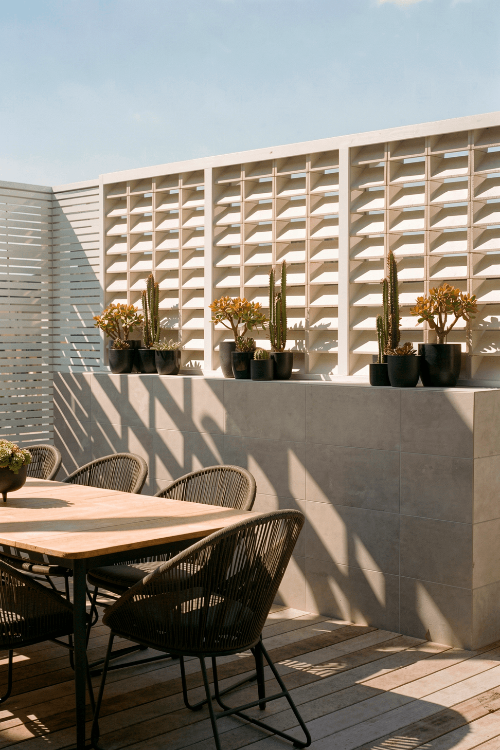 A bespoke screen constructed from Mutina bricks provides privacy while filtering light and air. The textured brickwork creates a distinctive backdrop to the timber entertaining deck.