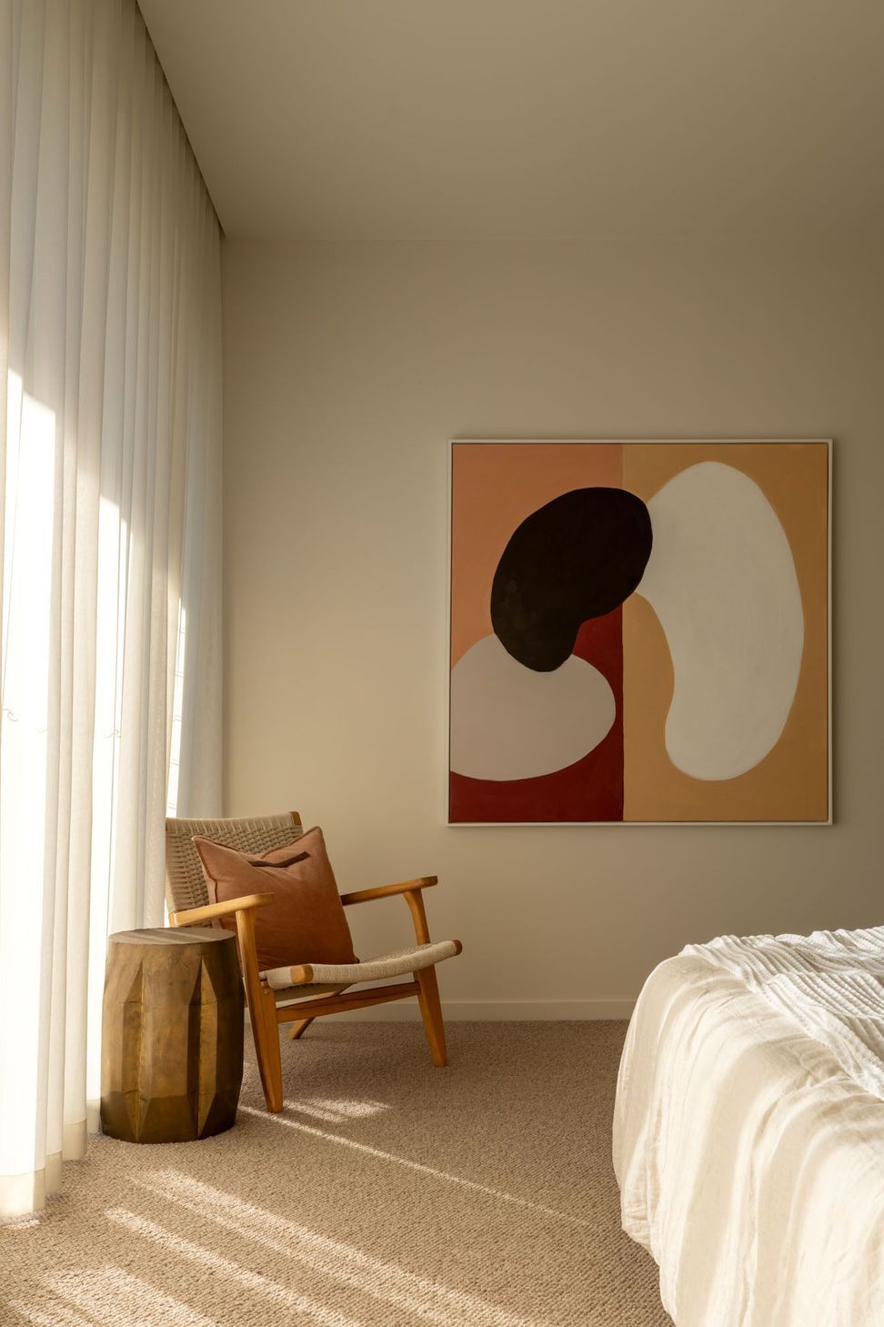 Warrego - Bedroom. Bedroom corner with a timber chair and abstract artwork.