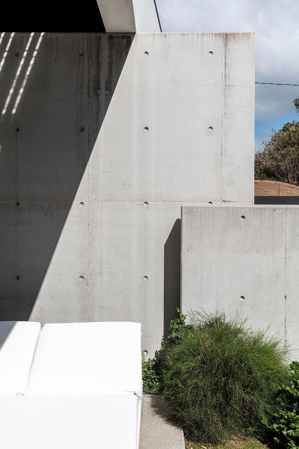 Morrison Residence - Exterior. Off-form concrete walls stepping in the sunlight.