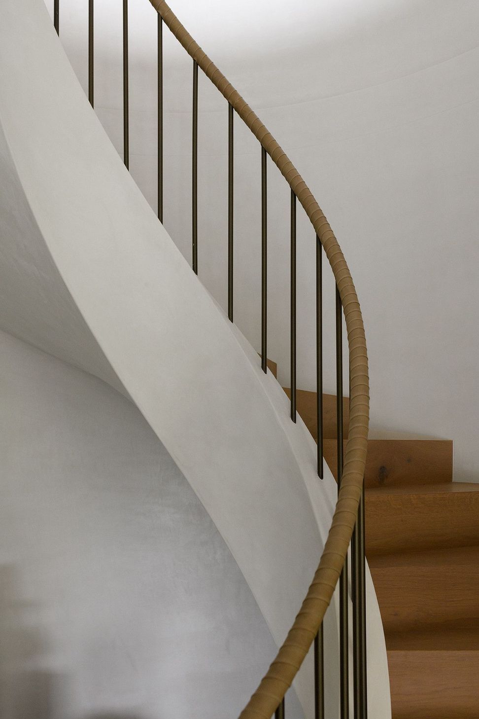 Villa Solare - Staircase. Curved stair with a slender timber handrail.