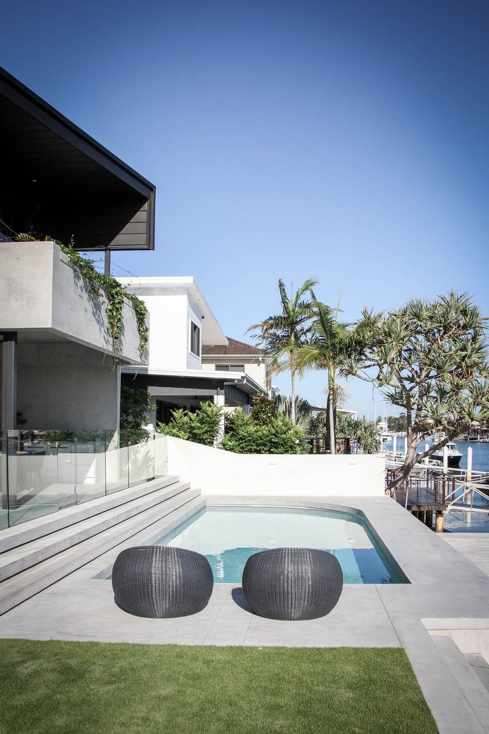 M Residence - Pool. Pool terrace with a glass balustrade and wide steps.