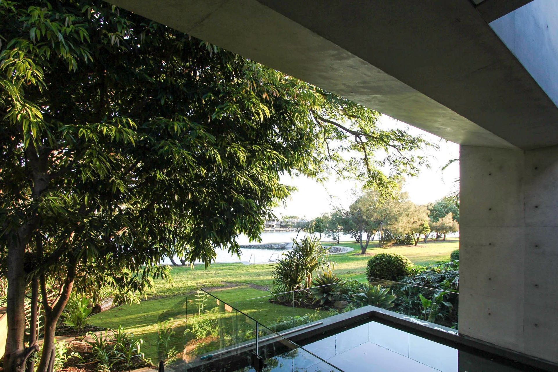 McGovern Residence - Garden. Concrete eave framing a view to the lawn and trees.