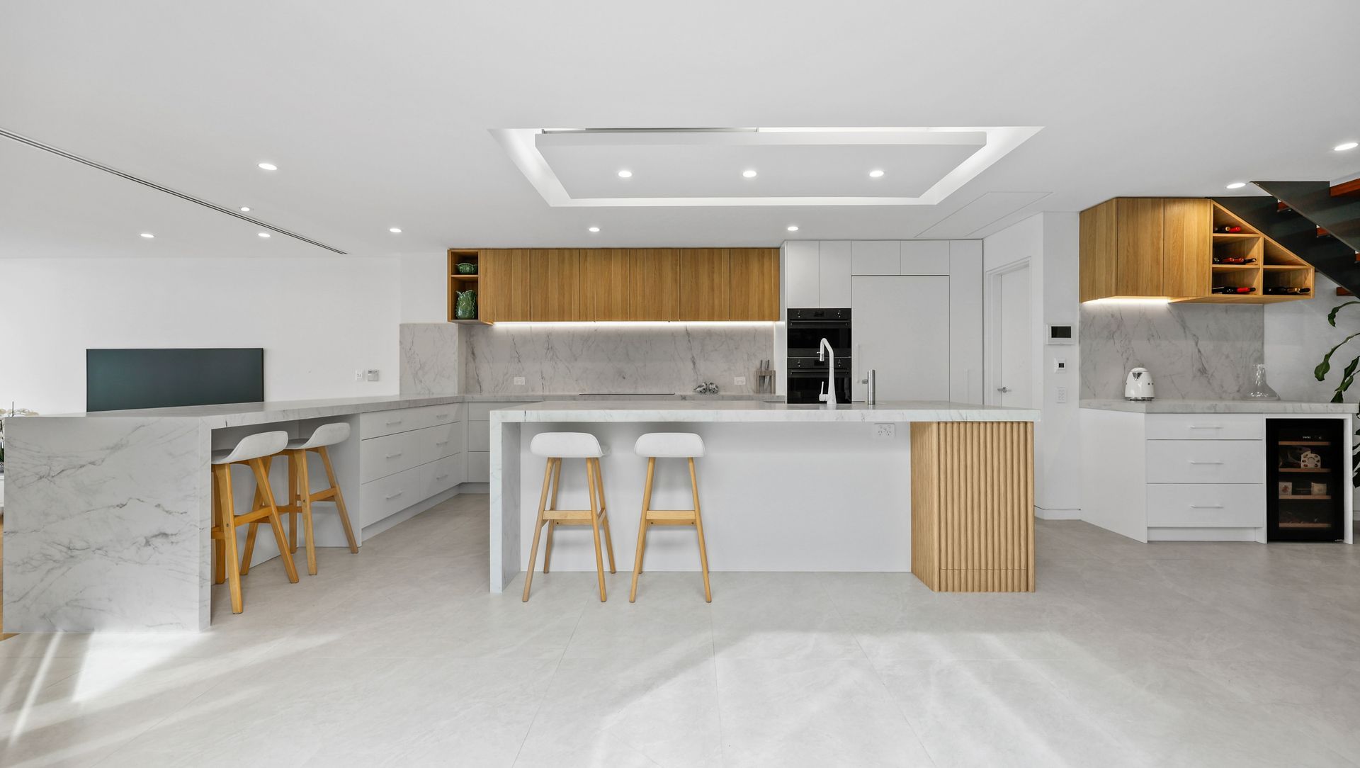 Cabarita contemporary style white kitchen with timber essence banner