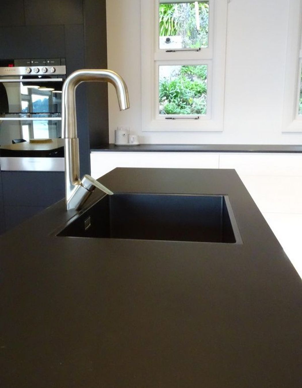 Detail of the black sink with the black kitchen island