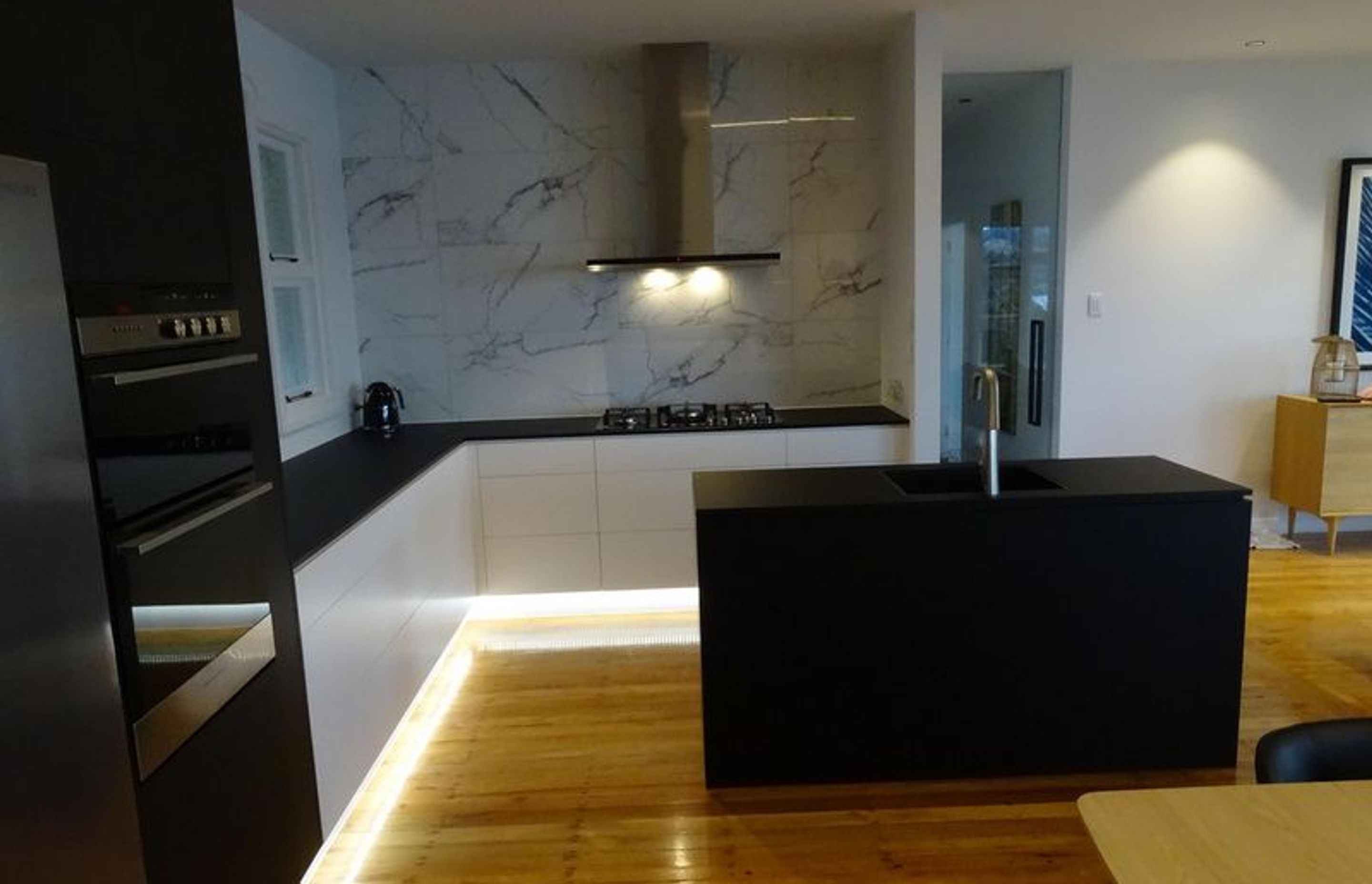 The black bench top, lighting and marble at this modern kitchen in Dunedin