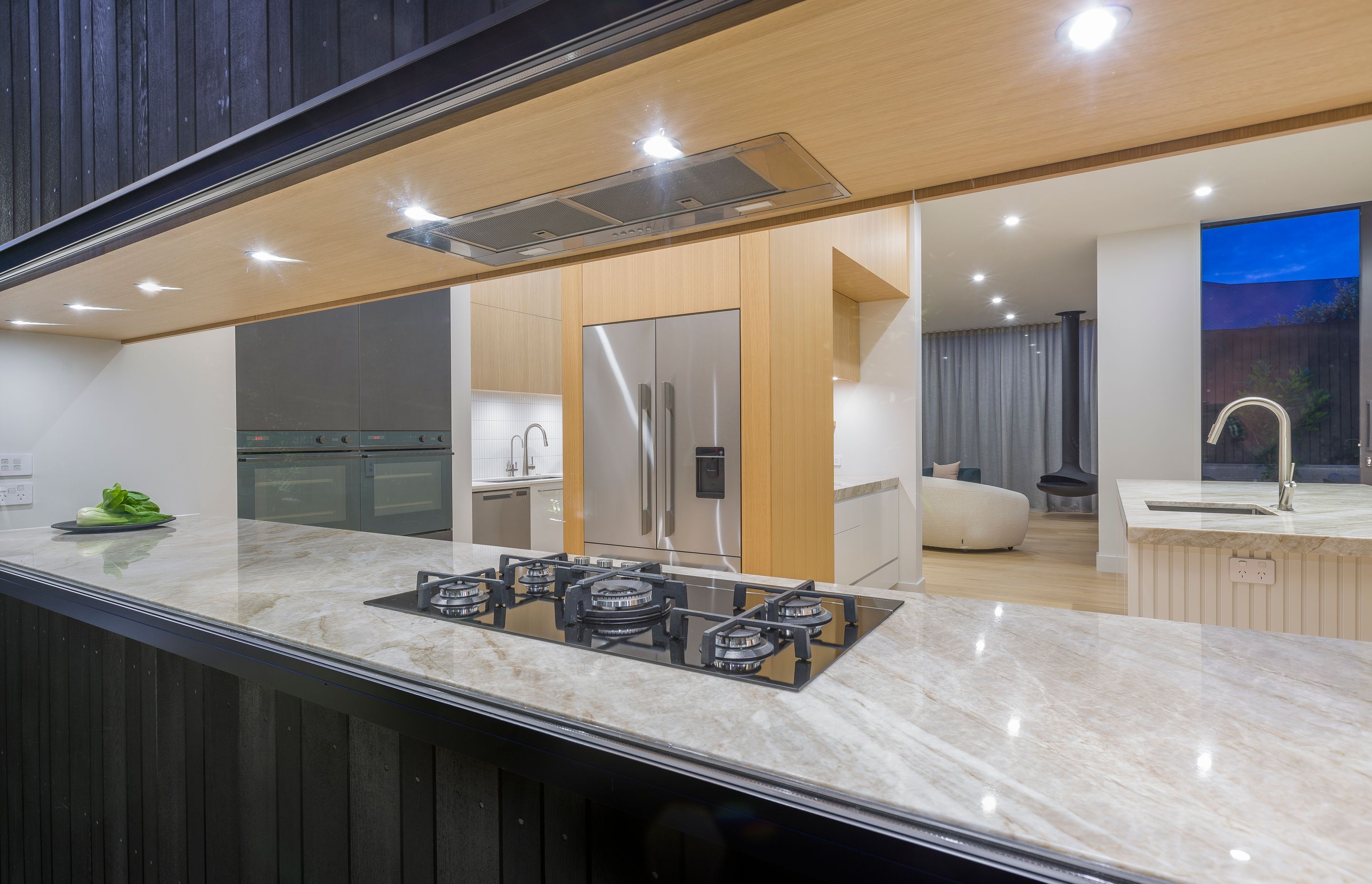This view from outside reveals the scullery beyond and the attention to fine detailing of each material to the glass frame; a careful collaboration of several trades at site.  Wanting appliances hidden yet intuitively accessible, we tucked the fridge and 