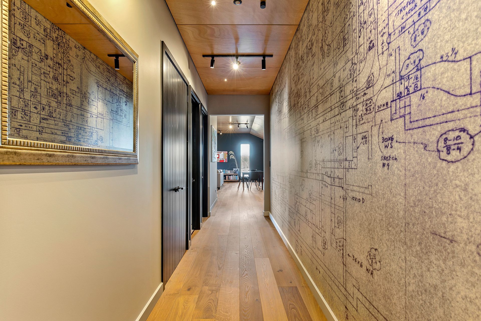 In the hallway, doors in Resene 'Double Foundry' look smart against walls painted Resene 'Napa' and a blueprint of a ventilation system, originally drawn by owners father, has been printed on vinyl as a unique piece of wall art.