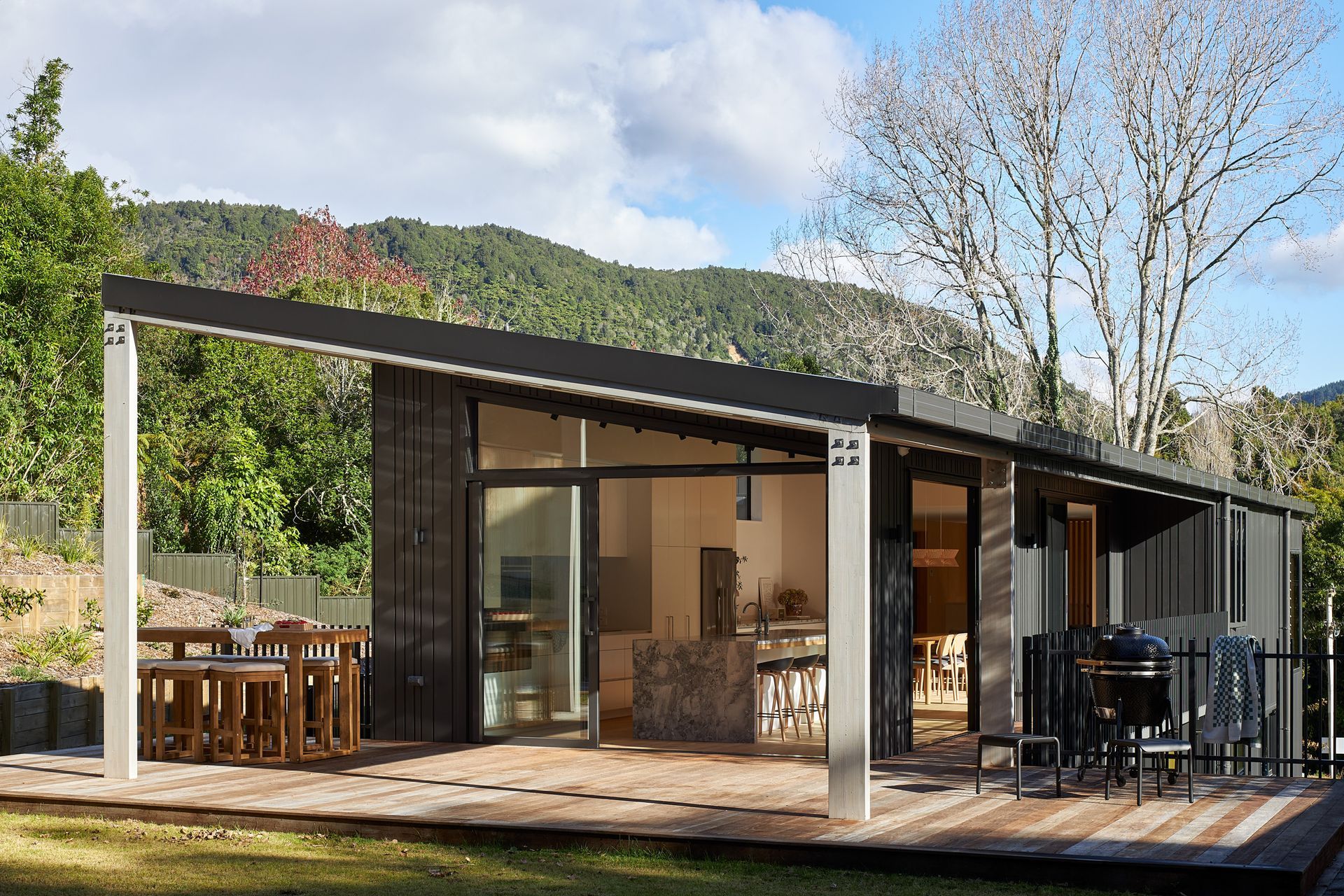 The rear elevation opens effortlessly to the lawn, extending the home's living spaces into the landscape. Expansive glazing strengthens the connection between inside and out, while the slate grey Nu-Wall cladding provides a calm, understated backdrop that allows the surrounding landscape to take centre stage.