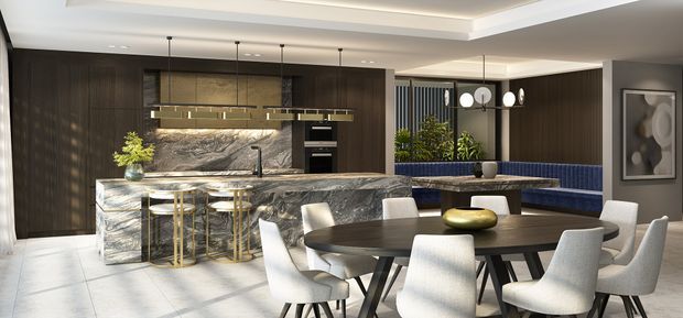 A sophisticated open-plan kitchen and dining area with dark timber cabinetry, a dramatic veined stone island and splashback, brass pendant lighting, and a large dark dining table surrounded by upholstered chairs. A curved blue banquette, indoor planting, and contemporary artwork add visual accents. The space has layered recessed ceilings and polished, high-contrast finishes.