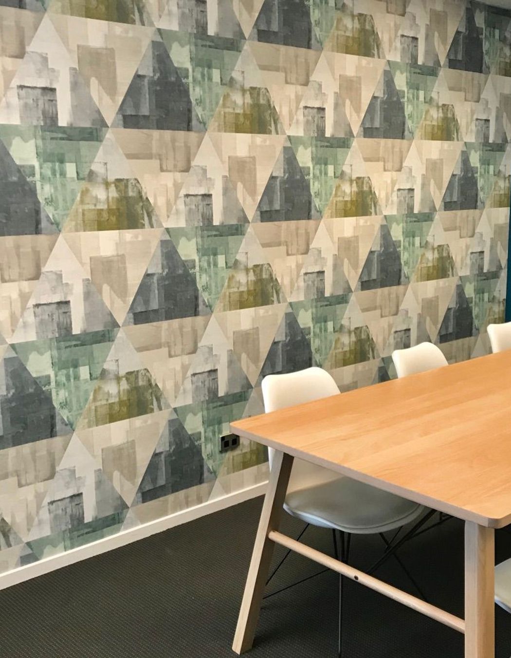 Wallpaper in a large scale mid century inspired design makes a statement in this boardroom space.
