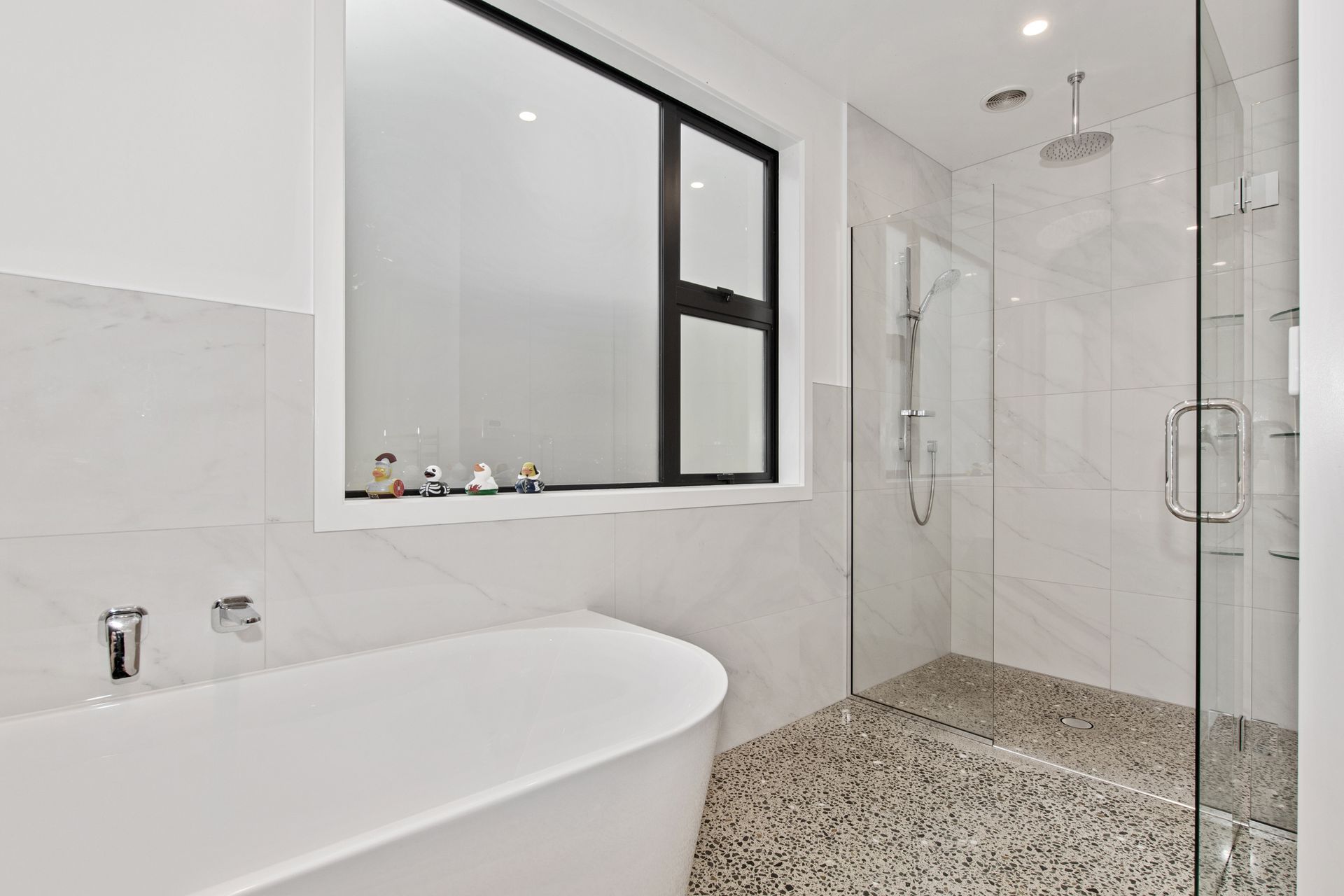 Family bathroom with polished concrete floor leading into tiled shower